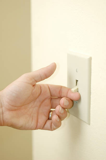 Handing turning on wall light switch. stock photo