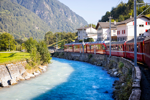 Holidays in Switzerland - The Bernina Express passes the town of Poschavio in the Val Poschiavo valley in the Bernina Mountains in the Alps.