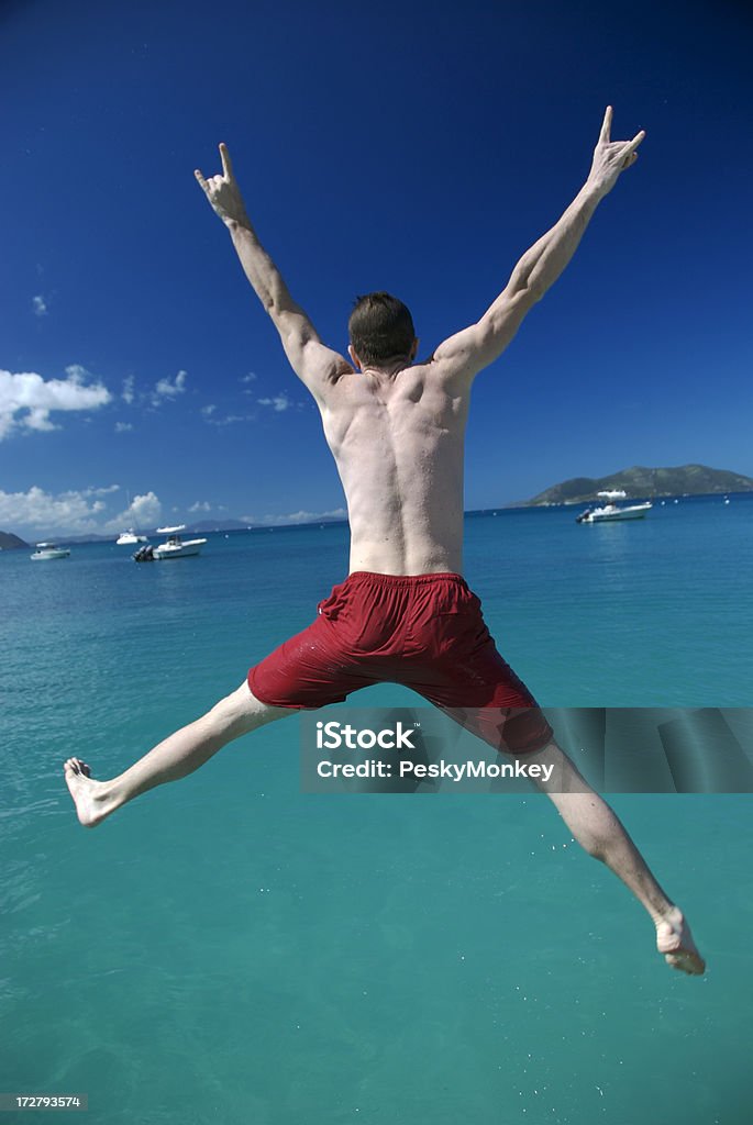 Człowiek w czerwone spodenki skoków do morza - Zbiór zdjęć royalty-free (Z rozrzuconymi rękami i nogami)