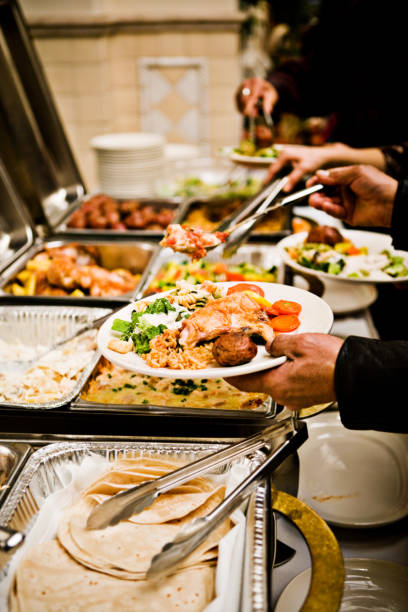 grabbing food in a buffet line stock photo