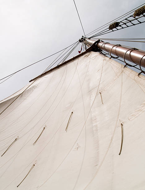 Gaff rig sail Gaff rig sail and wood mast on an old sailboat. gaff rigged stock pictures, royalty-free photos & images