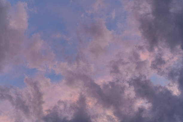 istock Pink and purple tinted  clouds on blue sky at sunset. 1727938874