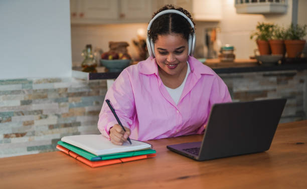 istock Young african woman doing webinar at home using wireless headphone and computer laptop 1727943892