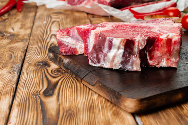 istock Raw T-bone steak with herbs on wooden board 1727944268