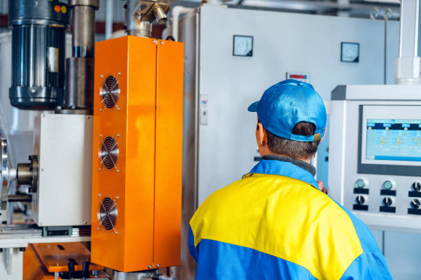 istock Man worker in manufacturing plant at cable factory machine control computer panel 1727944554