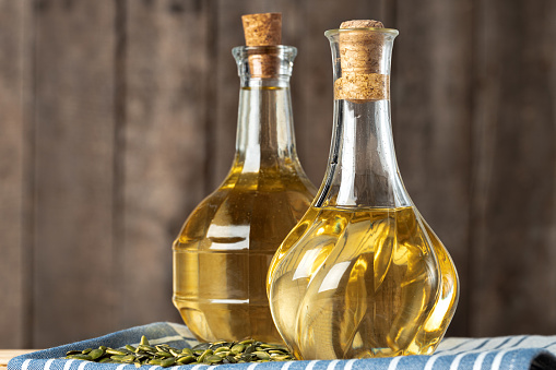 Olive oil bottle on wooden table.