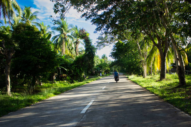Biker with tricycle on Philippines Biker with tricycle on the roads of Palawan, Philippines. philippines tricycle stock pictures, royalty-free photos & images