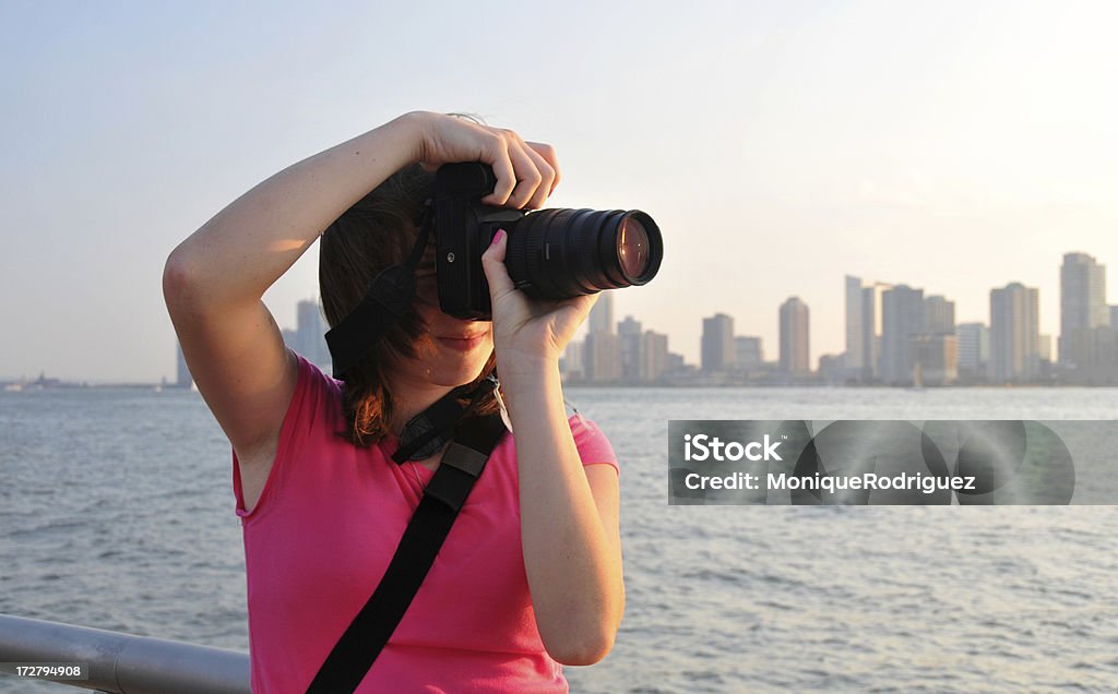 NYC Photographer Teen girl photographing the sunset in New York City and the New York Harbor overlooking New Jersey from Chelsea Piers. Adolescence Stock Photo