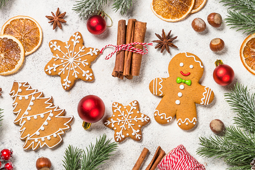Christmas gingerbread cookies with spices and holidays decorations at white table. Top view image.