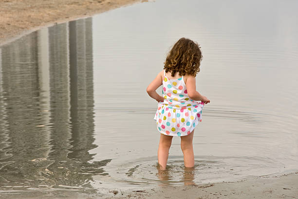 chica en la playa - wading child beach sundress fotografías e imágenes de stock