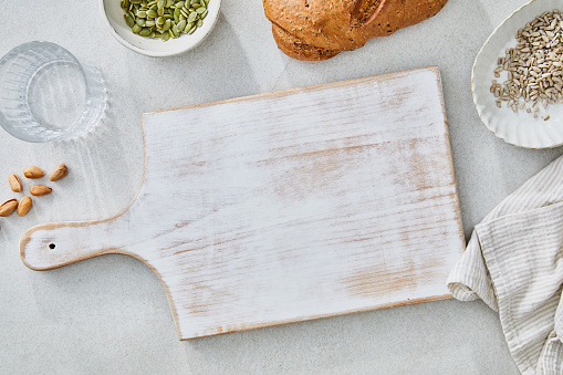White rustic cutting board background, food preparation, on a white granite ceramic natural kitchen or restaurant table, representing a wellbeing and a healthy lifestyle, food indulgence, top view image with a copy space, perfect for product placement