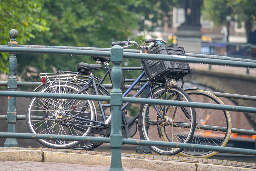 Netherlands. Summer day in Amsterdam. Two bicycles parked near the railing of a bridge over a canal
