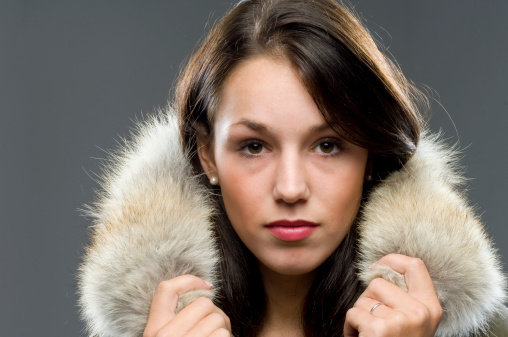 close up of gorgeous brunette wearing fur collar around her neck looking at the camera