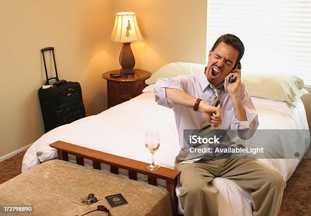 Business Traveler On Phone Yawning Stock Photo - Download Image Now - Hotel Room, Adult, Alcohol - Drink