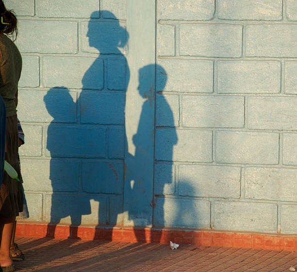 This small family stands outside a clinic in an impoverished country. They have been waiting hours in the late afternoon sun.