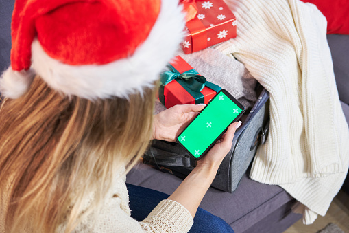 A woman makes an order through a mobile application on a smartphone. Traveling for the Christmas holidays.