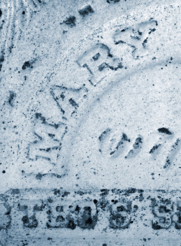 An extremely old tombstone (by North American standards) shows the name of the one it honors on its weathered surface.