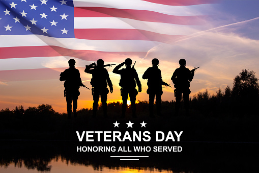 Silhouettes of soldiers with USA flag against the sunset. Greeting card for Veterans Day, Memorial Day, Independence Day