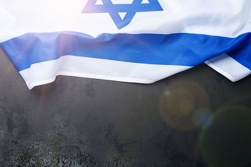 USA Israel flags. Two American and Israeli flags lie on black old concrete texture background opposite each other conveys partnership between two states through the main symbols of these countries.