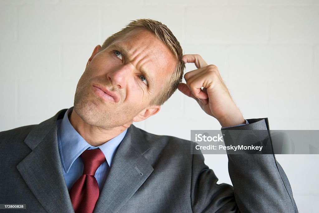 Thinking Businessman Scratching Head Looking Up Thinking businessman scratching his head and looking up with a perplexed expression Scratching Head Stock Photo