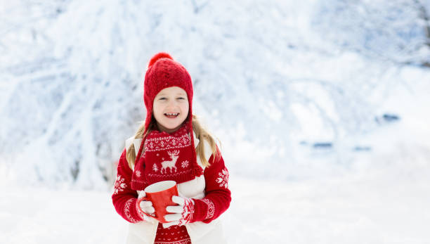 istock Child drinking chocolate on Christmas in snow 1728008782