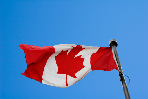 An Alberta and Canada flag waving.