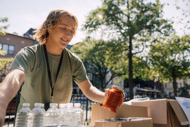 istock Young man volunteering and packing donation boxes 1728009900