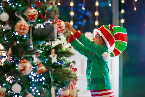 istock Child decorating Christmas tree. Kid on Xmas eve. 1728011019