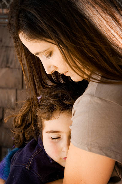 Dormire bambina con le braccia della madre - foto stock