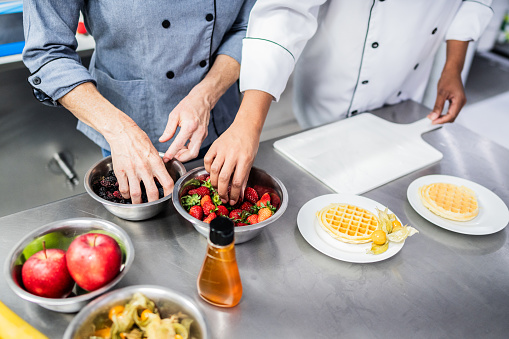 Chefs preparing food at commercial kitchen