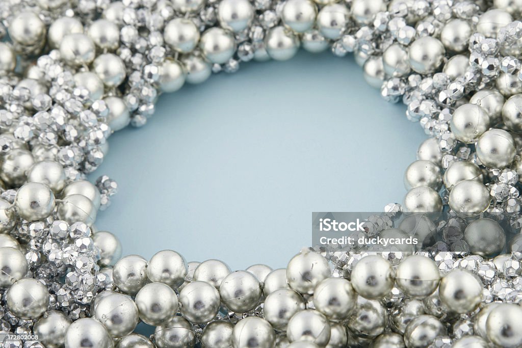 Silver Beads Silver beads on a light blue background. Space for text in the center. Pearl Jewelry Stock Photo