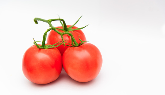 Fresh ripe red tomatoes bunched on a white background. Vegetables tomatoes