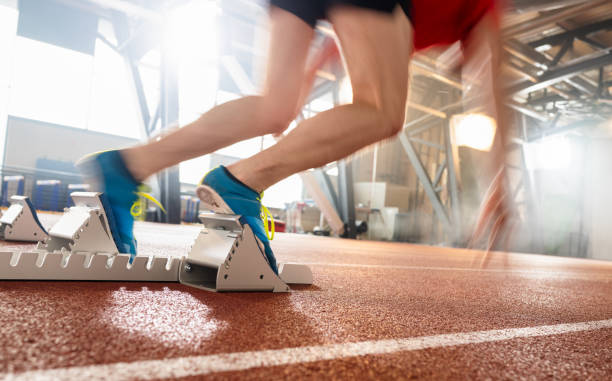 бегун, стоящий на стартовом блоке на трассе - hurdle hurdling track and field stadium exercise equipment стоковые фото и изображения