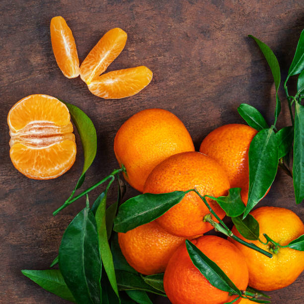 istock Fresh mandarin oranges fruit or tangerines with leaves on rustic wooden table, top view. Flat lay 1728028429