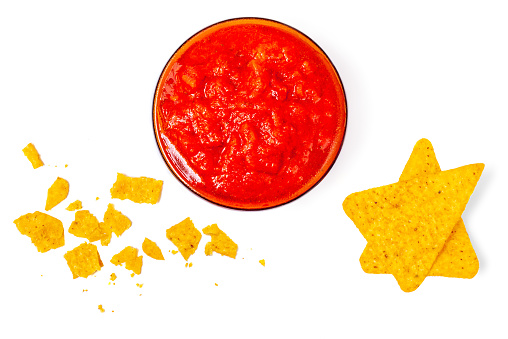 Nachos chips with salsa sauce isolated on white background. Salty chips and crumbs  Top view. Flat lay.
