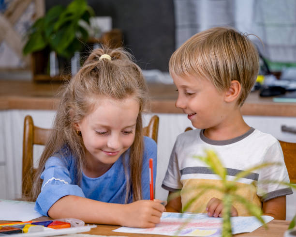 istock Sister Helps Her Brother to Draw with Colored Pencils 1728036836