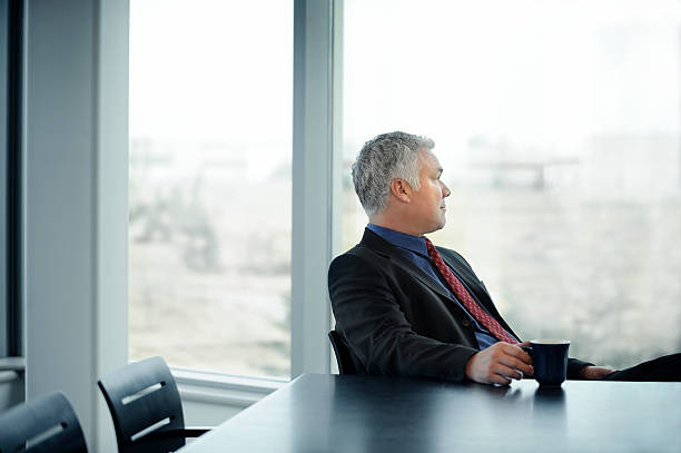 tranquila reflectivo ejecutivo - thinking business ceo board room fotografías e imágenes de stock