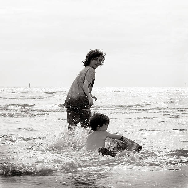 兄弟、ビーチで遊ぶ - parker brothers 写真 ストックフォトと画像