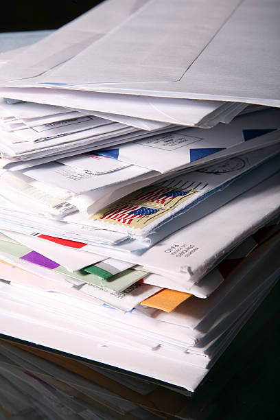 Stack of Junk Mail and Unpaid Bills Piles of envelopes stacked indicating an over load of mail. united states postal service photos stock pictures, royalty-free photos & images