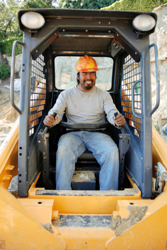 Royalty free image of a bobcat operator having fun as he works.