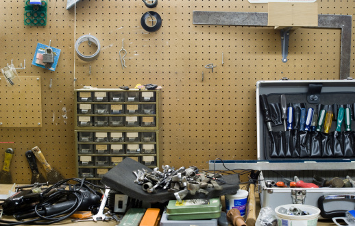 A cluttered work bench with pegboard and hooks to move around and hang whatever you want.