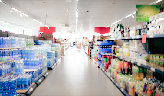 Supermarket shelfs with variety drink bottles. Grocery store aisle with water and juice choice