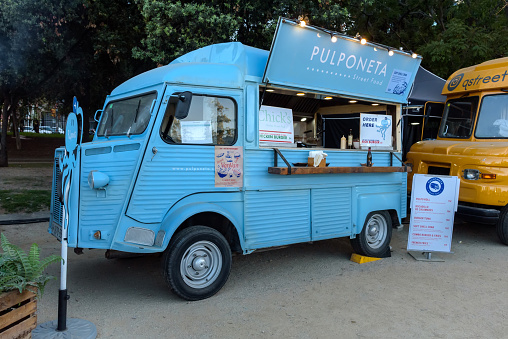 Barcelona, Spain - October 24, 2023: Retro van prepared for fast food sale. Food truck at an event in the park.
