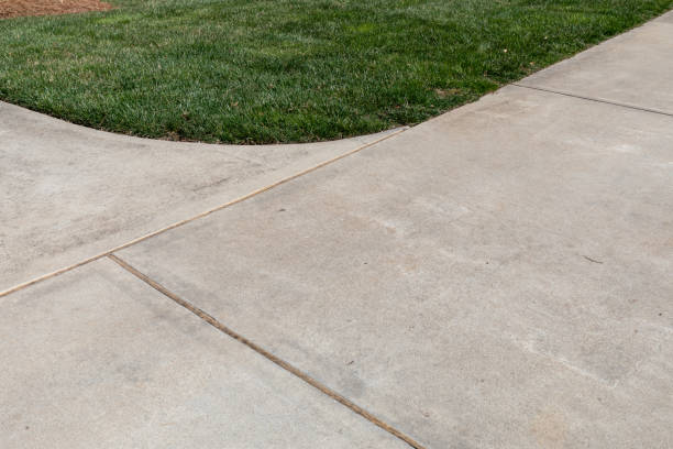 istock Curving intersection of concrete paths edged in thick green grass, creative copy space, horizontal aspect 1728060824