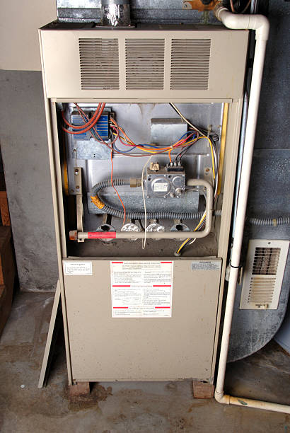 Home Basement Furnace Unit Old-technology, natural-gas furnace in a typical basement installation of a home. furnace photos stock pictures, royalty-free photos & images