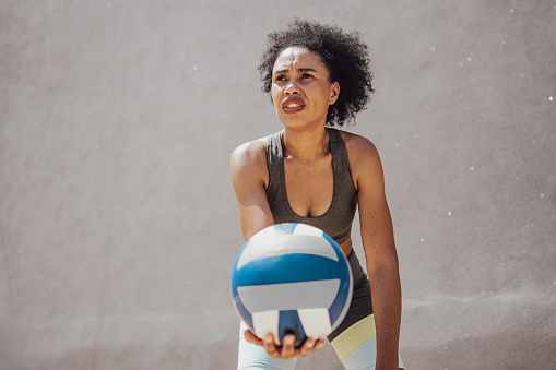 Mid adult woman playing volleyball at sports court