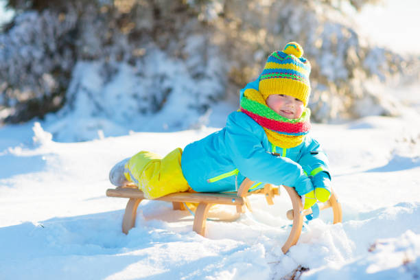 istock Baby boy on sled. Child sledding. Kid with sledge 1728075475