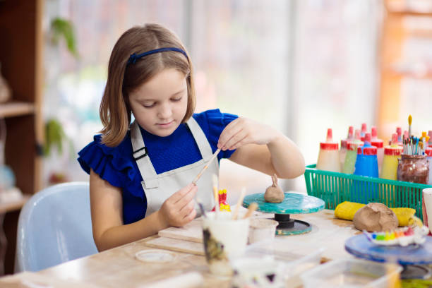 istock Child at pottery wheel. Kids arts and crafts class 1728075553