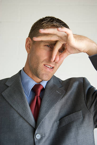 istock Businessman Pinches His Nose with Grimace 172807655