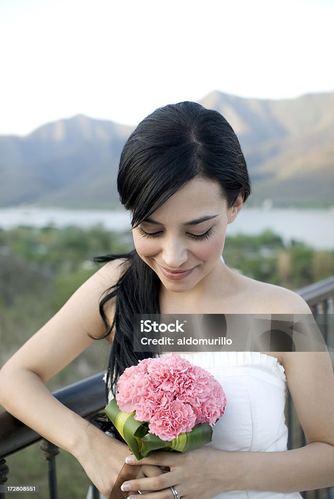 Splendida sposa guardando il suo bouquet - Foto stock royalty-free di Abbigliamento formale
